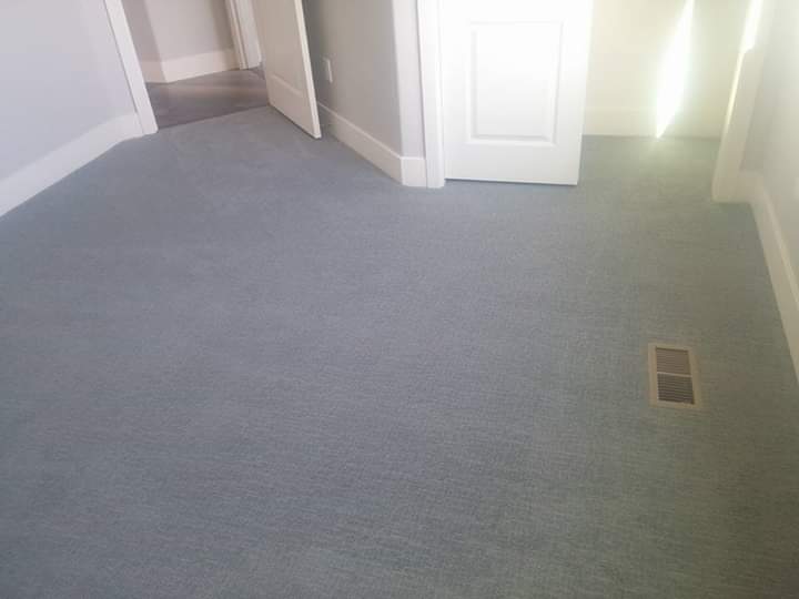 A finished bedroom with new blue-gray carpet